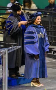Graduation ceremony with graduates in academic regalia celebrating achievement at CAES News event.