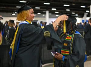 Graduation ceremony with students in caps and gowns at CAES News event.