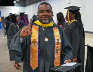 Graduation graduate in cap and gown celebrating academic achievement at ceremony.