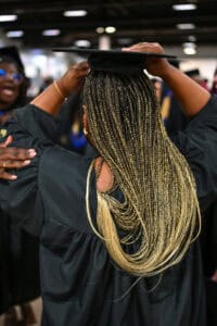 Graduation cap and gown celebration at a university event, diverse students in academic regalia.