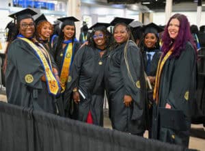 Graduates in caps and gowns celebrating at a graduation ceremony.