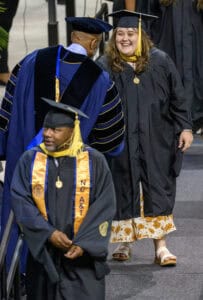 Graduation ceremony with students in caps and gowns celebrating achievement.