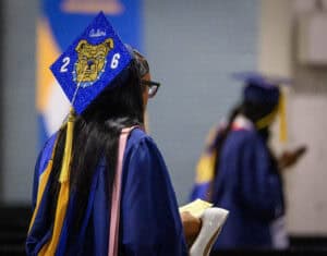Graduation cap with "Class of 2026" and bulldog logo at a university ceremony.