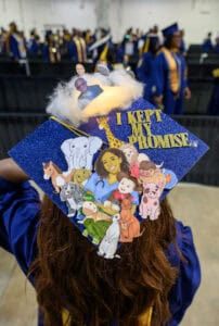 Graduation cap decorated with animals and motivational message at commencement ceremony.
