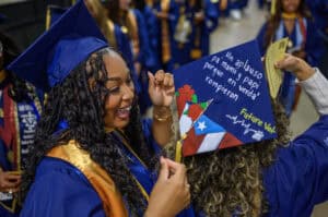 Celebrating graduation with proud students wearing caps and gowns at a commencement ceremony.