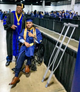 Accessible graduation ceremony with graduate in wheelchair and faculty member celebrating achievemen.