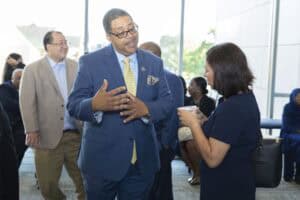 Engaged professionals discussing at a business networking event in a modern conference center.